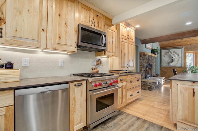 kitchen with beamed ceiling, light brown cabinets, light wood-type flooring, and stainless steel appliances