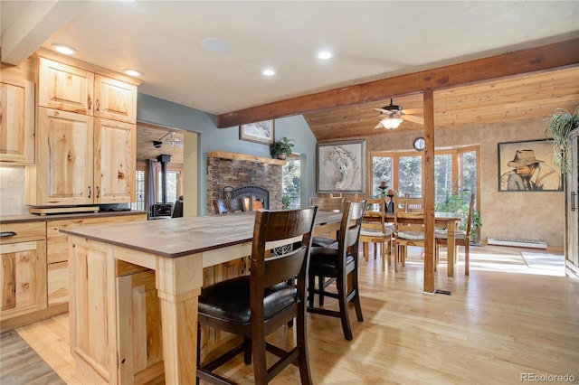 kitchen with a breakfast bar, light brown cabinets, light wood-type flooring, and plenty of natural light