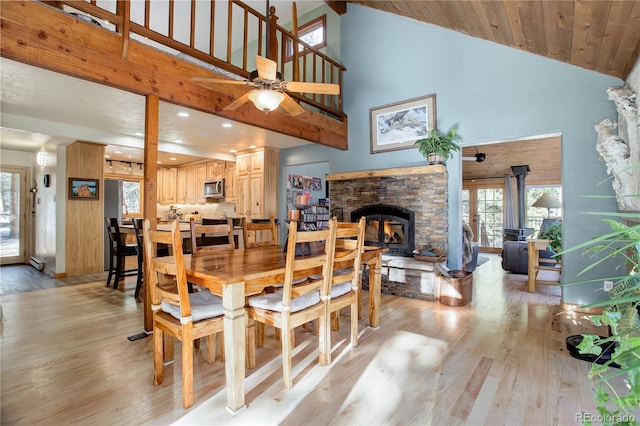 dining room featuring ceiling fan, light wood-type flooring, and high vaulted ceiling