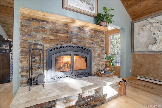 interior details featuring baseboard heating, a wood stove, and hardwood / wood-style floors