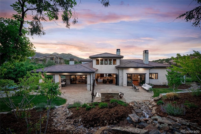 back house at dusk with a patio area