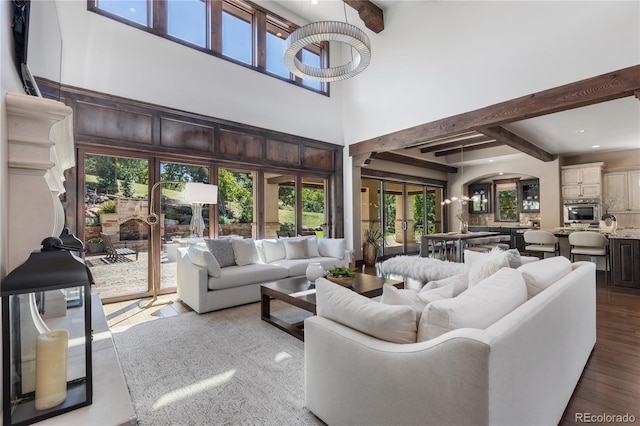 living room with french doors, beamed ceiling, a towering ceiling, and hardwood / wood-style floors