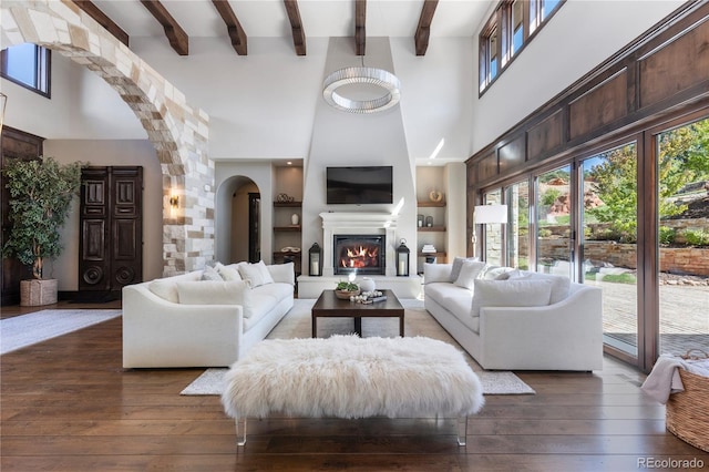 living room featuring a high ceiling, dark wood-type flooring, and beamed ceiling