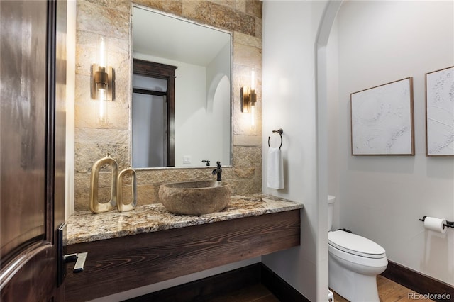 bathroom with tile walls, vanity, and toilet