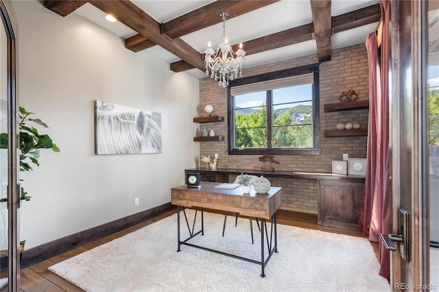 office with a chandelier, brick wall, beamed ceiling, and hardwood / wood-style flooring