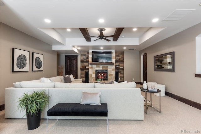 carpeted living room featuring ceiling fan and a fireplace