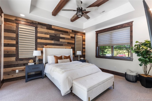 carpeted bedroom with ceiling fan, a raised ceiling, and wood walls