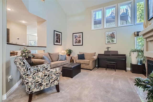 living room featuring a towering ceiling, light colored carpet, and a healthy amount of sunlight