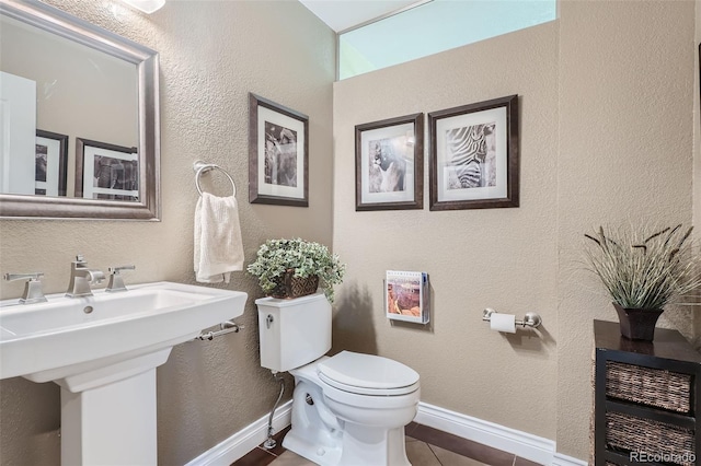 bathroom with heating unit, tile patterned floors, sink, and toilet