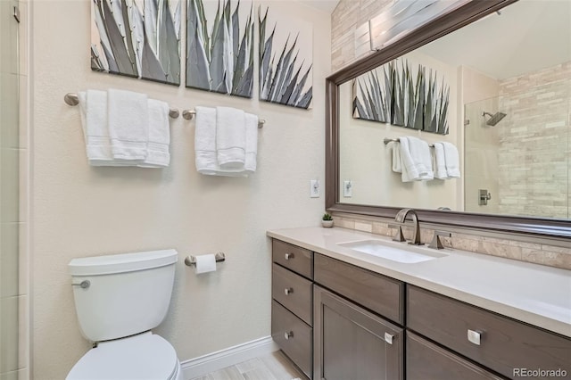 bathroom featuring a tile shower, hardwood / wood-style floors, vanity, and toilet