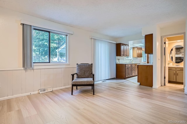 2514 S Elkhart St, Aurora, CO 80014 - living area with light wood-type flooring, wainscoting, and a textured ceiling