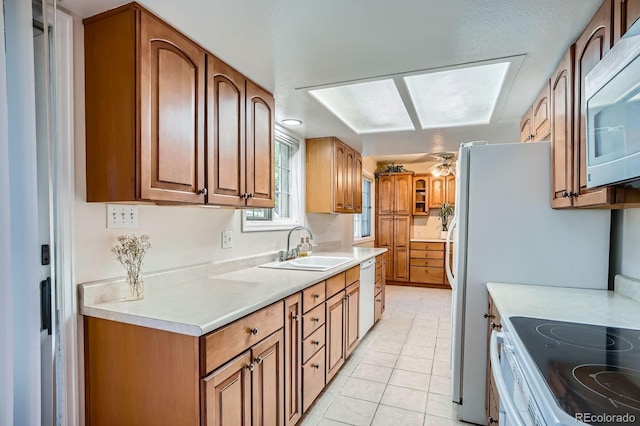 2514 S Elkhart St, Aurora, CO 80014 - kitchen featuring white appliances, light countertops, light tile patterned floors, and brown cabinetry