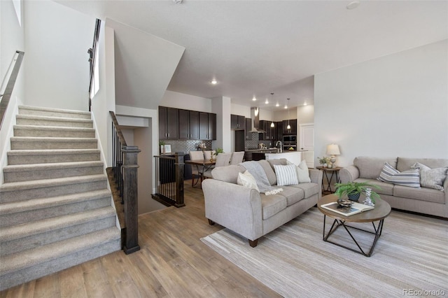 living room featuring light wood-type flooring, stairway, and recessed lighting