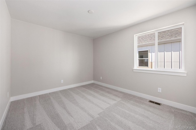 unfurnished room featuring carpet and baseboards