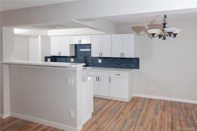 7255 E Quincy Ave Unit 205, Denver, CO 80237 - kitchen with tasteful backsplash, a chandelier, light wood finished floors, baseboards, and white cabinets