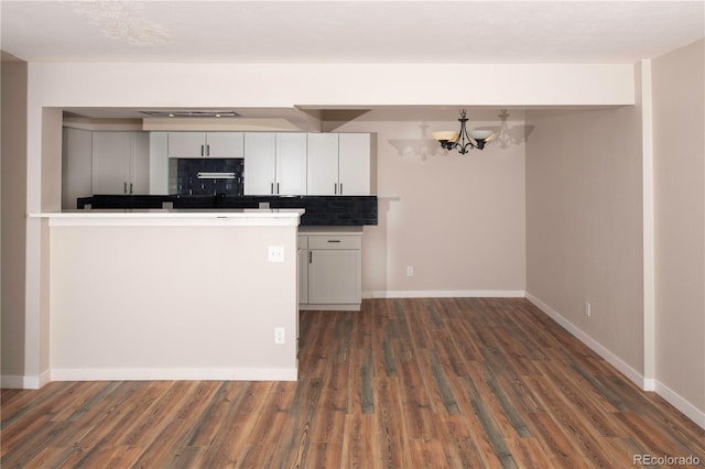 7255 E Quincy Ave Unit 205, Denver, CO 80237 - kitchen with dark wood-style floors, a chandelier, baseboards, white cabinetry, and decorative backsplash