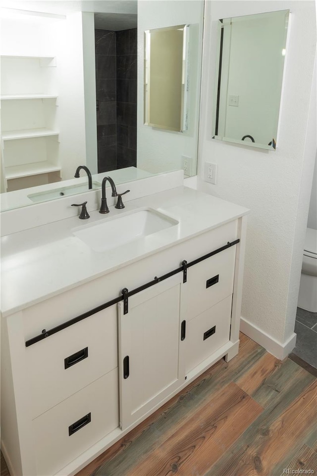 7255 E Quincy Ave Unit 205, Denver, CO 80237 - bathroom with wood finished floors, vanity, toilet, and baseboards