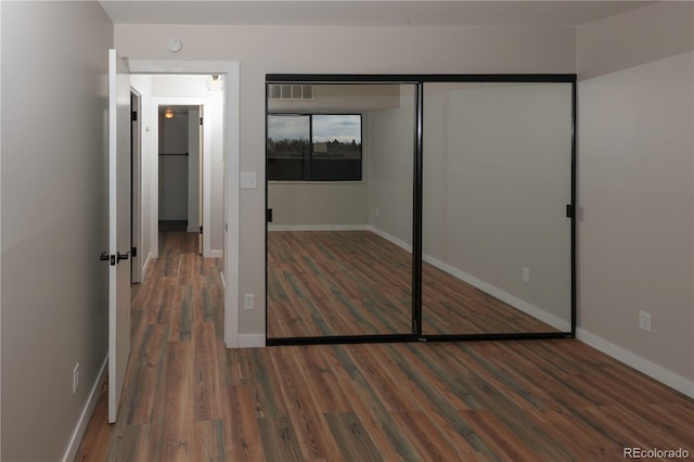7255 E Quincy Ave Unit 205, Denver, CO 80237 - unfurnished bedroom featuring wood finished floors, baseboards, and a closet