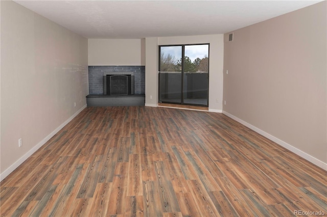 7255 E Quincy Ave Unit 205, Denver, CO 80237 - unfurnished living room featuring a fireplace, wood finished floors, and baseboards