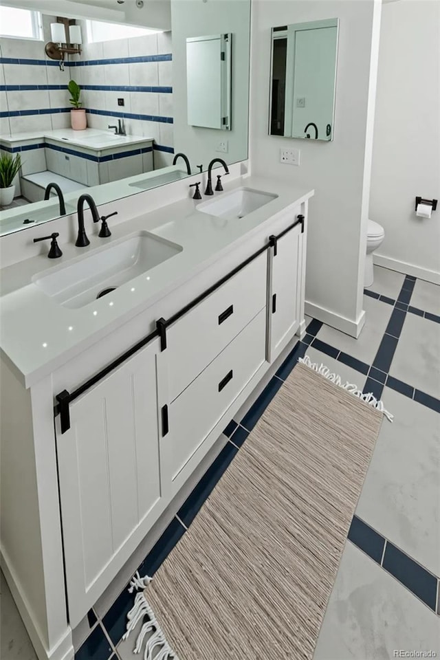 7255 E Quincy Ave Unit 205, Denver, CO 80237 - full bath featuring double vanity, toilet, and baseboards