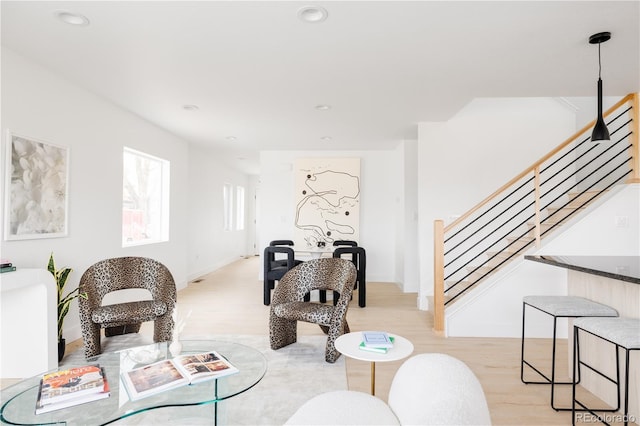 living area featuring stairs, recessed lighting, baseboards, and light wood-style floors