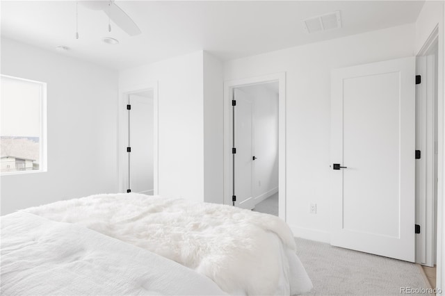 bedroom featuring a ceiling fan, light colored carpet, and visible vents