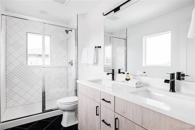 full bathroom with toilet, double vanity, a sink, and tile patterned floors