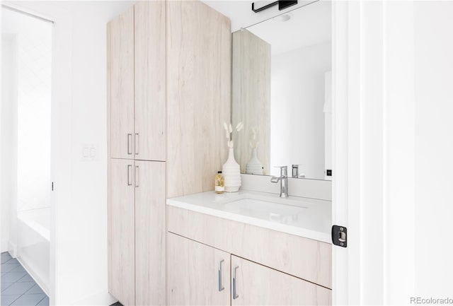 full bathroom with a bathtub, vanity, and tile patterned floors