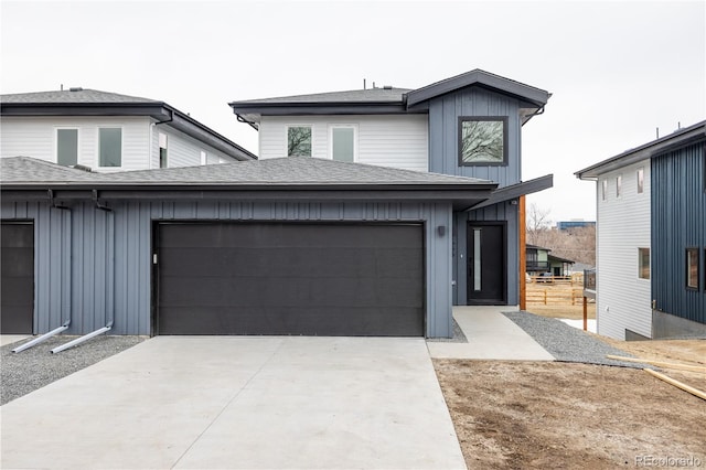 view of front facade featuring an attached garage, driveway, a shingled roof, and board and batten siding