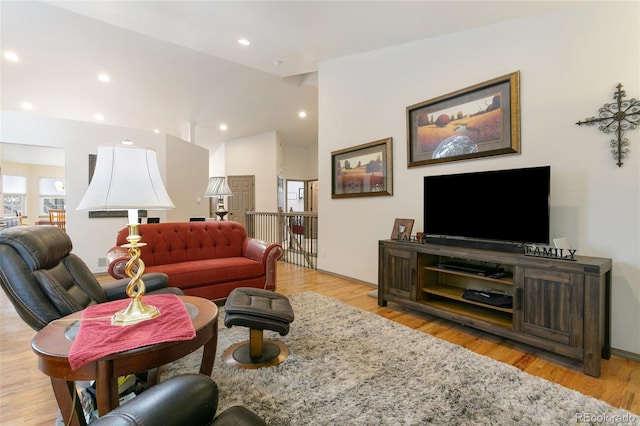 living room featuring vaulted ceiling and light hardwood / wood-style flooring