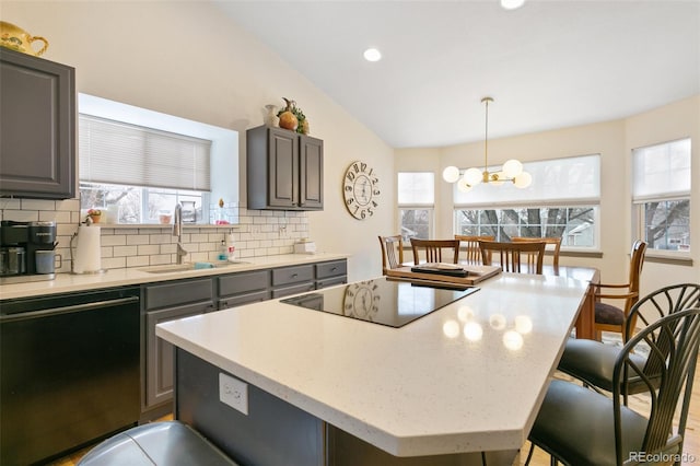 kitchen featuring a kitchen island, pendant lighting, tasteful backsplash, sink, and black appliances