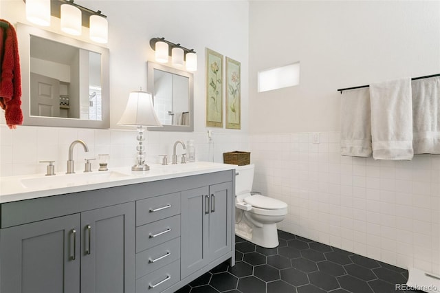 bathroom featuring tile walls, vanity, tile patterned floors, and toilet