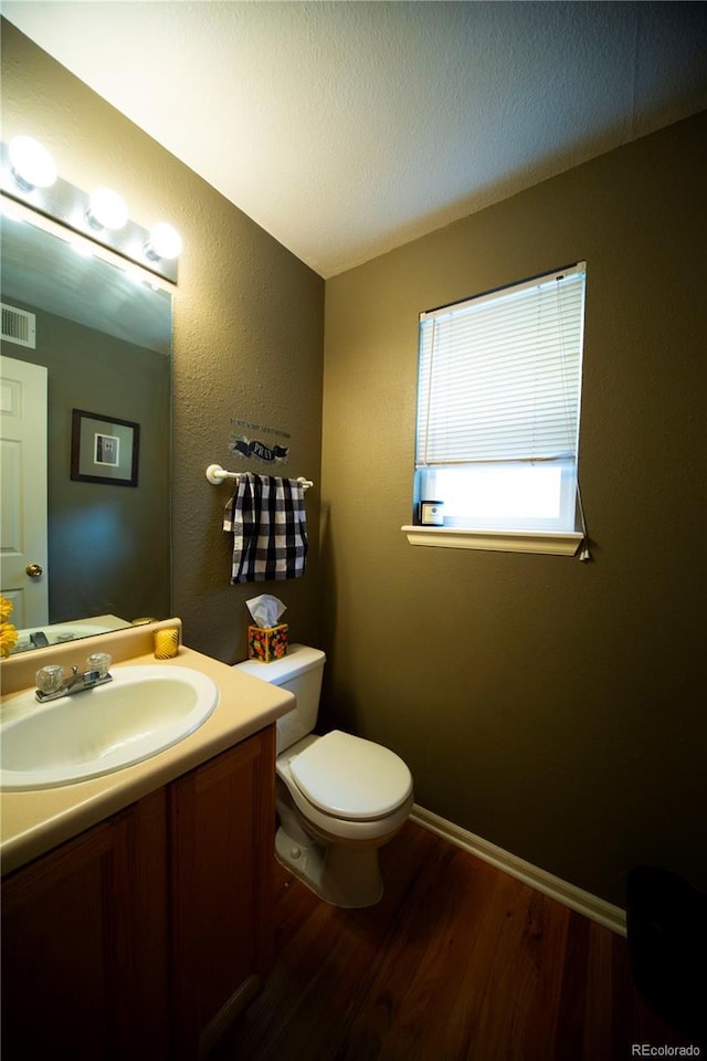 9950 Sydney Ln, Highlands Ranch, CO 80130 - half bathroom with wood finished floors, vanity, toilet, and baseboards