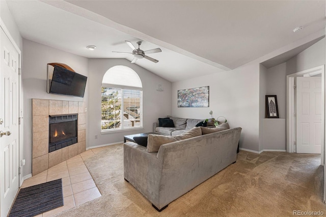 living room featuring a fireplace, baseboards, light colored carpet, ceiling fan, and vaulted ceiling