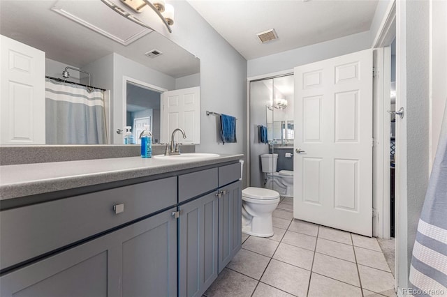 bathroom with visible vents, toilet, vanity, and tile patterned flooring