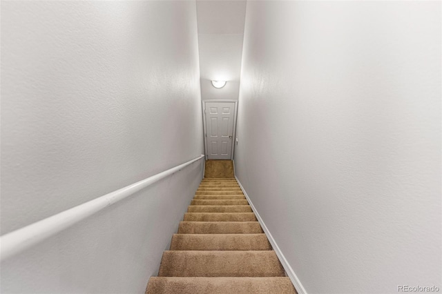 staircase featuring baseboards