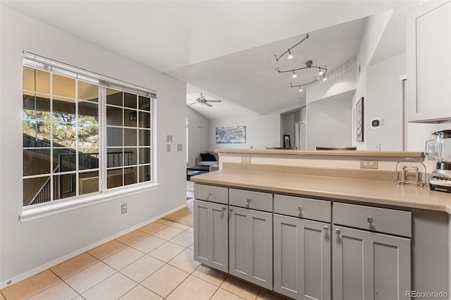 kitchen with gray cabinets, a peninsula, light tile patterned floors, baseboards, and ceiling fan