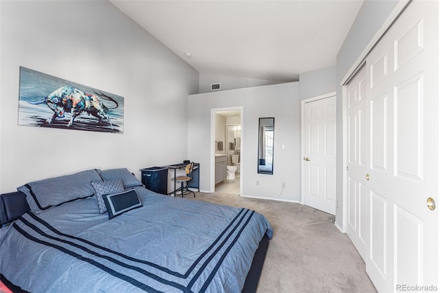 bedroom featuring lofted ceiling, carpet, ensuite bathroom, baseboards, and a closet