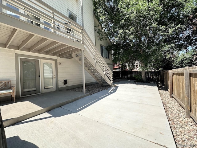 view of patio with a fenced backyard and stairway