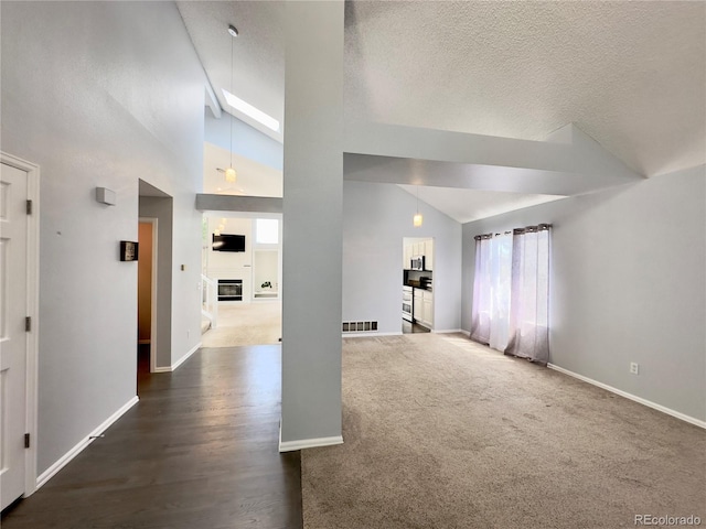 interior space featuring a healthy amount of sunlight, baseboards, visible vents, and a glass covered fireplace