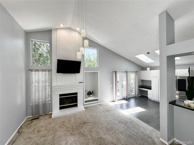 living area featuring dark carpet, a brick fireplace, and a wealth of natural light