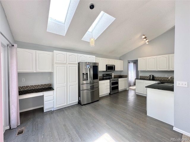 kitchen featuring stainless steel appliances, dark wood-type flooring, a sink, white cabinetry, and dark countertops