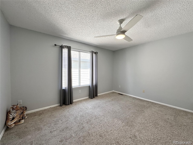 empty room with carpet floors, visible vents, a ceiling fan, a textured ceiling, and baseboards