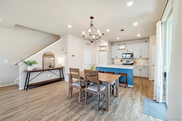 8586 Holman Ct Unit A, Arvada, CO 80005 - dining area featuring light wood finished floors, stairway, baseboards, recessed lighting, and a chandelier