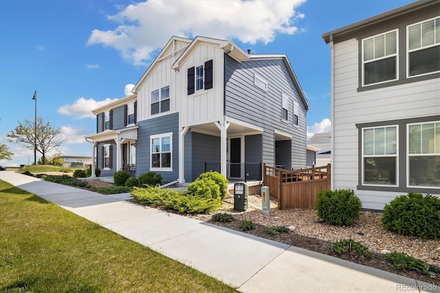 8586 Holman Ct Unit A, Arvada, CO 80005 - view of front of home featuring board and batten siding, covered porch, and a front lawn