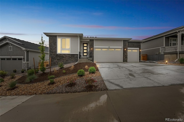 1148 Sunlit Dr, Castle Rock, CO 80109 - view of front of home with stone siding, a garage, and concrete driveway
