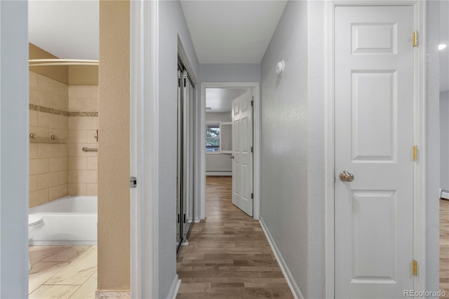 2190 S Holly St Unit 207, Denver, CO 80222 - hallway featuring a baseboard heating unit and hardwood / wood-style floors