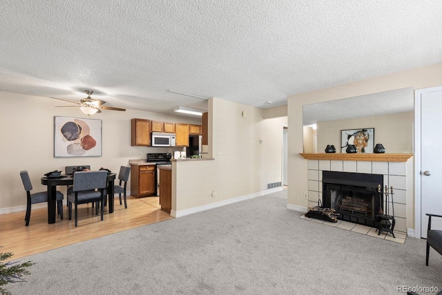 10212 W 80th Dr Unit C, Arvada, CO 80005 - living room with light carpet, a ceiling fan, a fireplace, and a textured ceiling