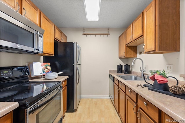 10212 W 80th Dr Unit C, Arvada, CO 80005 - kitchen with appliances with stainless steel finishes, light wood finished floors, brown cabinets, and light countertops