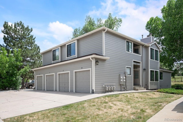 10212 W 80th Dr Unit C, Arvada, CO 80005 - view of front of property with driveway, an attached garage, and a chimney